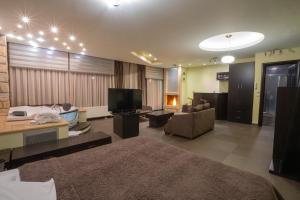 a large living room with a couch and a television at Nymfes Hotel in Kato Loutraki
