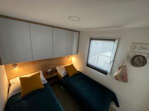 two beds in a small room with a window at Mobile home Mare Blu in Rovanjska