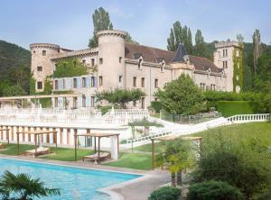 a large castle with a swimming pool in front of it at Château de Fontager in Serves-sur-Rhône