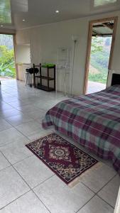 a bedroom with a bed and a rug on the floor at Quinta La Lomita in Turrialba