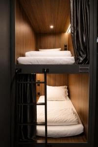 two bunk beds in a small room with wood at Wink at McCallum Street in Singapore