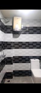 a bathroom with a black and white tiled wall at The Royal Lavender in Rānchī