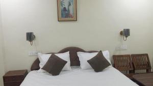a bedroom with a bed with white sheets and pillows at The Royal Lavender in Rānchī