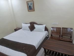 a bedroom with two beds and a chair in it at The Royal Lavender in Rānchī +9 photos