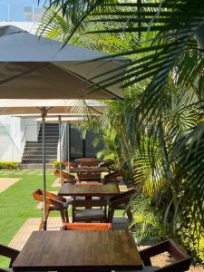 a group of tables and chairs under an umbrella at Hotel Viajante in Landusane