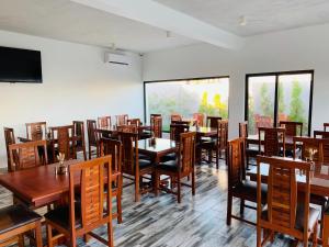a dining room with wooden tables and chairs at Hotel Viajante in Landusane