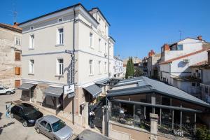 a street with cars parked in front of a building at Hotel Galija in Pula
