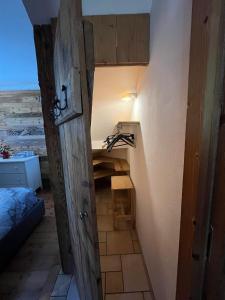 a door leading to a room with a bed and a desk at Casa Lazer in Tonadico