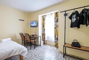 a room with a bed and a table and chairs at Miriam Inn, Chaka in Nyeri