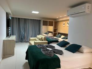 a hotel room with two beds and a living room at Flat Premium Sea View - Tabatinga Beach in Conde