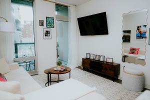 a living room with a white couch and a tv at Luxury 2BR Apartment with Pool, Balcony & Parking in Cambridge