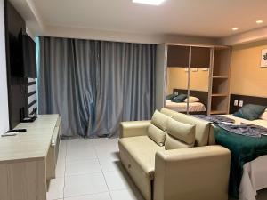 a living room with a couch and a bed at Flat Premium Sea View - Tabatinga Beach in Conde