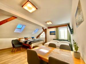 a room with two beds and a table and chairs at Hotel Garni Villa Areka in Český Krumlov