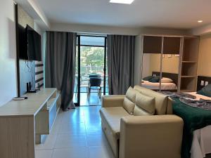 a living room with a couch and a bedroom at Flat Premium Sea View - Tabatinga Beach in Conde