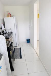 a kitchen with a refrigerator and a white tiled floor at Âncora Horto da barra in Barra dos Coqueiros +8 photos