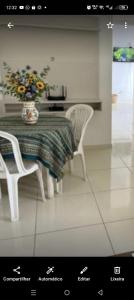 a dining room table with two chairs and a vase of flowers at Âncora Horto da barra in Barra dos Coqueiros