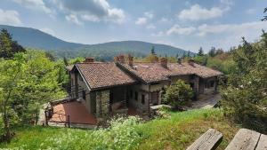 an old house on a hill with mountains in the background at Cascina Silene in Castelmarte