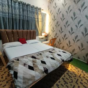 a bedroom with a bed in a room with curtains at Hotel Kalzug in Katihār