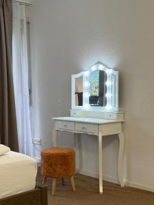 a white dressing table with a mirror on a wall at Rawda Ferien Wohnung in Interlaken