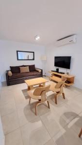 a living room with a couch and a table and chairs at Carilo - semipiso 3 ambientes 1ºpiso in Carilo