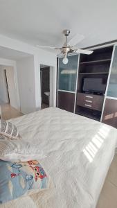 a bedroom with a large bed with a ceiling fan at Carilo - semipiso 3 ambientes 1ºpiso in Carilo