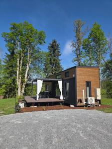 a tiny house with a porch and a roof at Tiny House Mountain View perfekt für Ruhesuchende in Köttmannsdorf