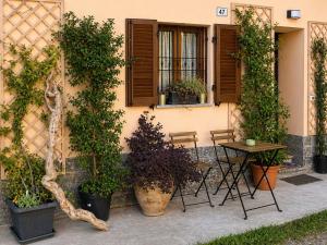 a table and chairs in front of a building with plants at La Casetta - Home Gallery in San Fiorano