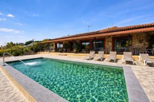 a swimming pool with chairs and a house at Bravaholidays-625-Silence in Terra Brava