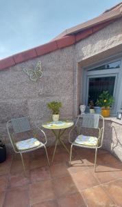 two chairs and a table on a patio at Stone House Premium Room in Porriño