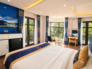 a bedroom with a large bed with blue walls and windows at Arina Luxury Hotel - Vincom Tay Ninh in Tây Ninh +115 photos