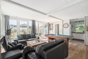 a living room with couches and a pool table at Vakantiehuis Rumah Kami - Julianadorp aan Zee in Julianadorp
