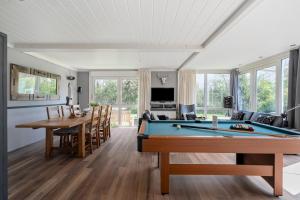 a living room with a pool table and a dining room at Vakantiehuis Rumah Kami - Julianadorp aan Zee in Julianadorp