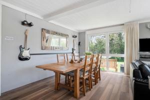 a dining room with a wooden table and chairs at Vakantiehuis Rumah Kami - Julianadorp aan Zee in Julianadorp +32 photos
