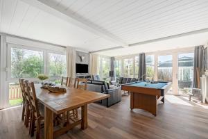a living room with a table and a pool table at Vakantiehuis Rumah Kami - Julianadorp aan Zee in Julianadorp