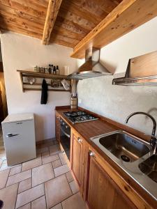 a kitchen with a sink and a stove at Casa Lazer in Tonadico +16 photos
