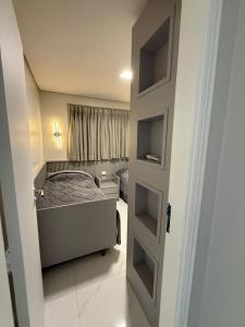 a small bedroom with a bed and a door at Charming Apartment in the Central Square in Bonito