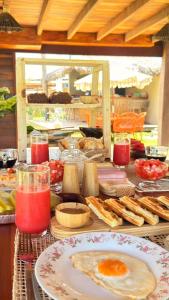 a table topped with plates of food and drinks at Áurea chalés in Tutóia