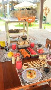 a table with a bunch of different types of food at Áurea chalés in Tutóia +40 photos