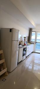 a kitchen with white appliances and a white refrigerator at Oasis Urbano Departamento Temporal in Santiago del Estero
