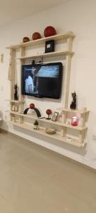 a television on a shelf in a living room at Oasis Urbano Departamento Temporal in Santiago del Estero