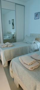 two beds in a room with towels on them at Oasis Urbano Departamento Temporal in Santiago del Estero