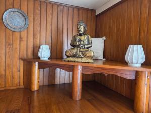 a statue sitting on a wooden table with two lamps at Aurelia Verdon in Angles