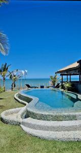 a swimming pool with stairs leading to the beach at Pousada San Antonio Praia in Caraíva