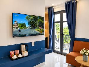 a living room with a tv and a window at Arina Luxury Hotel - Vincom Tay Ninh in Tây Ninh
