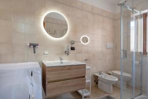 a bathroom with a sink and a toilet and a mirror at Levante Eight Sea View Apartment in Bari +21 photos