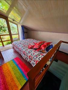 a bed with a colorful comforter in a room at Aguadulce Climbing House in Choachí
