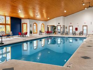 a swimming pool with blue water in a building at Comfort Suites Wisconsin Dells Area in Portage