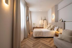 a white bedroom with a bed and a couch at Casa Palacio Taubin in Granada