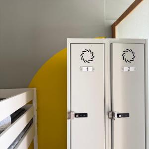 two bathroom stalls with doors in a room at A Beira Hostel in Aveiro