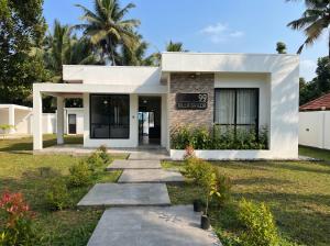 a white house with a walkway in front of it at Villa Grazia 99 in Katuneriya